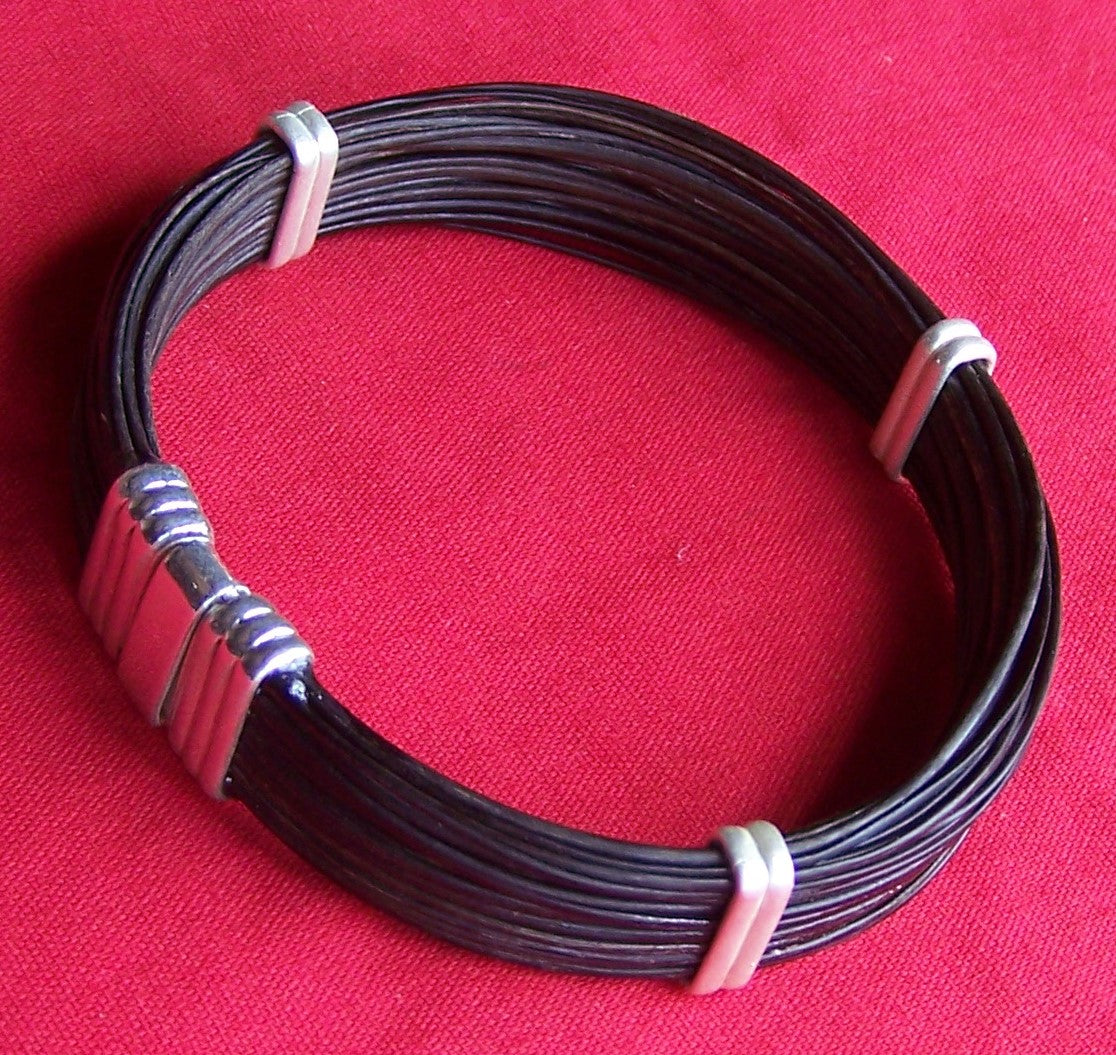 This flat round elephant hair bracelet is secured with sterling silver bands and clasp. The elephant hair bangle is perfect for ladies or men in the market for a lovely wrist or ankle adornment. - JJ85