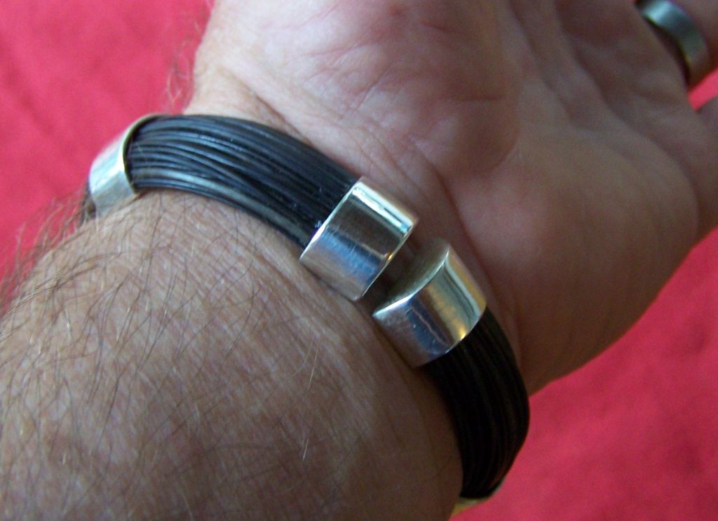 Half circle sterling silver bands hold dark elephant hair. Sterling silver end-caps and clasp finish the design. Very comfortable to wear. - HBS