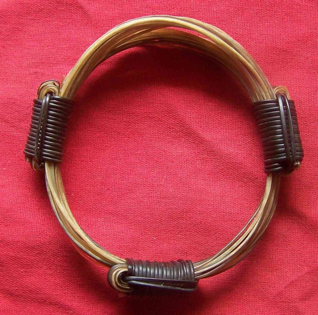 This angelic wreath of 14 white elephant hairs mixed with golden shades of light brown elephant hairs and fastened with 3 starkly contrasting black elephant hair knots. - BB6