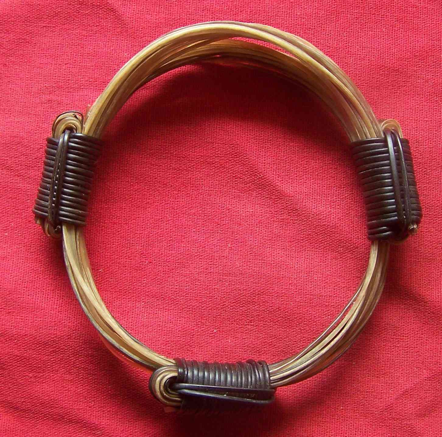 This angelic wreath of 14 white elephant hairs mixed with golden shades of light brown elephant hairs and fastened with 3 starkly contrasting black elephant hair knots. - BB6