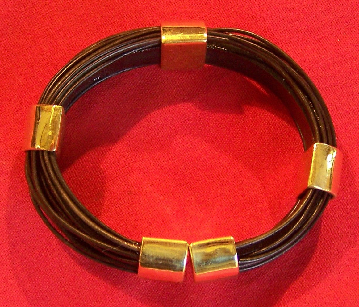 Half circle brass bands hold dark elephant hair. Golden brass end-caps and clasp finish the design. Very comfortable to wear. - HBS