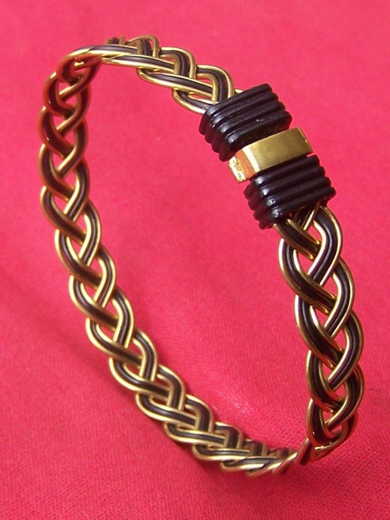 This elephant hair bracelet's unique design combines the blackest elephant hair with brass wire to create this woven braid masterpiece. The brass on black clasp continue the golden brass on black theme of the bracelet. - JE5R