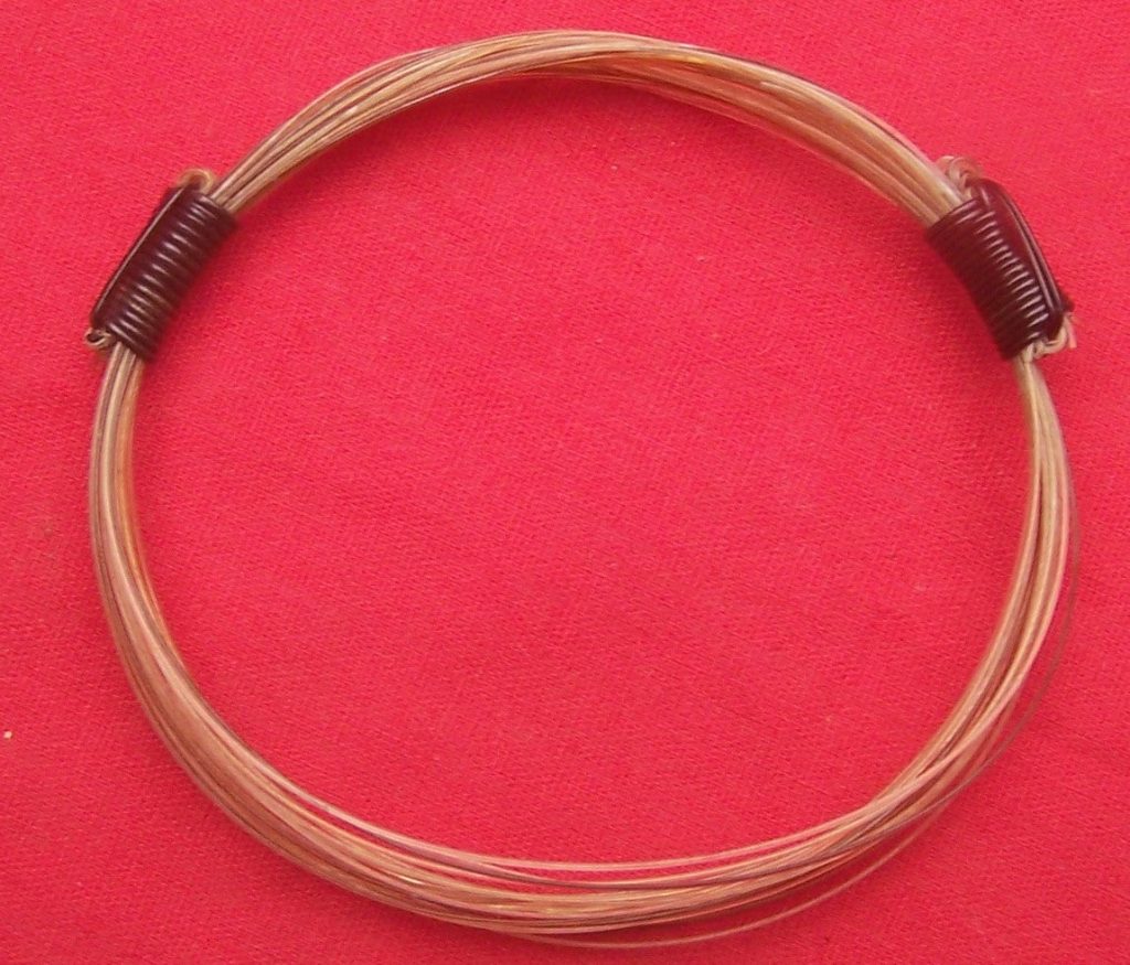Twenty white and lightly tanned giraffe hairs are fashioned and bound with 2 dark elephant hairs for a lovely earthy contrast. Very rare material composition. - JEGR1