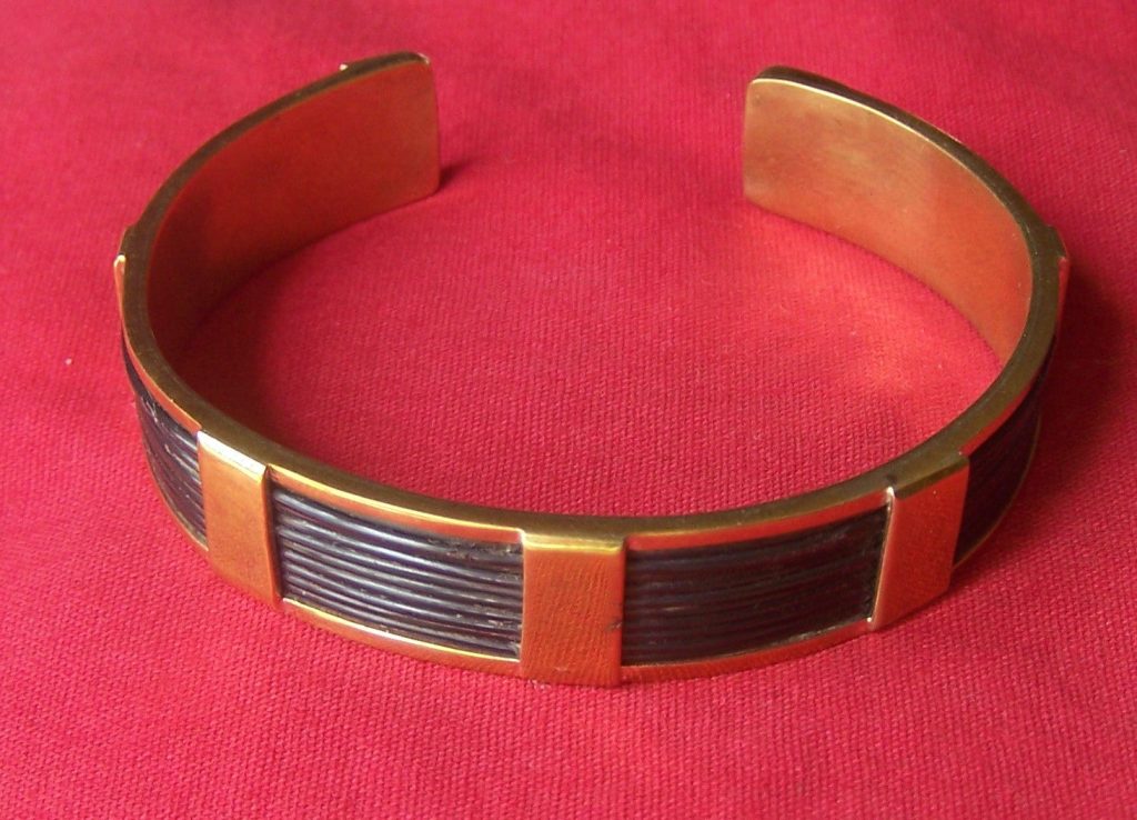 A brass circlet with dark, black or ebony elephant hairs held tightly betwixt its layers. Classy, naturally elegant, straight-out-of-Africa look and feel. - LG
