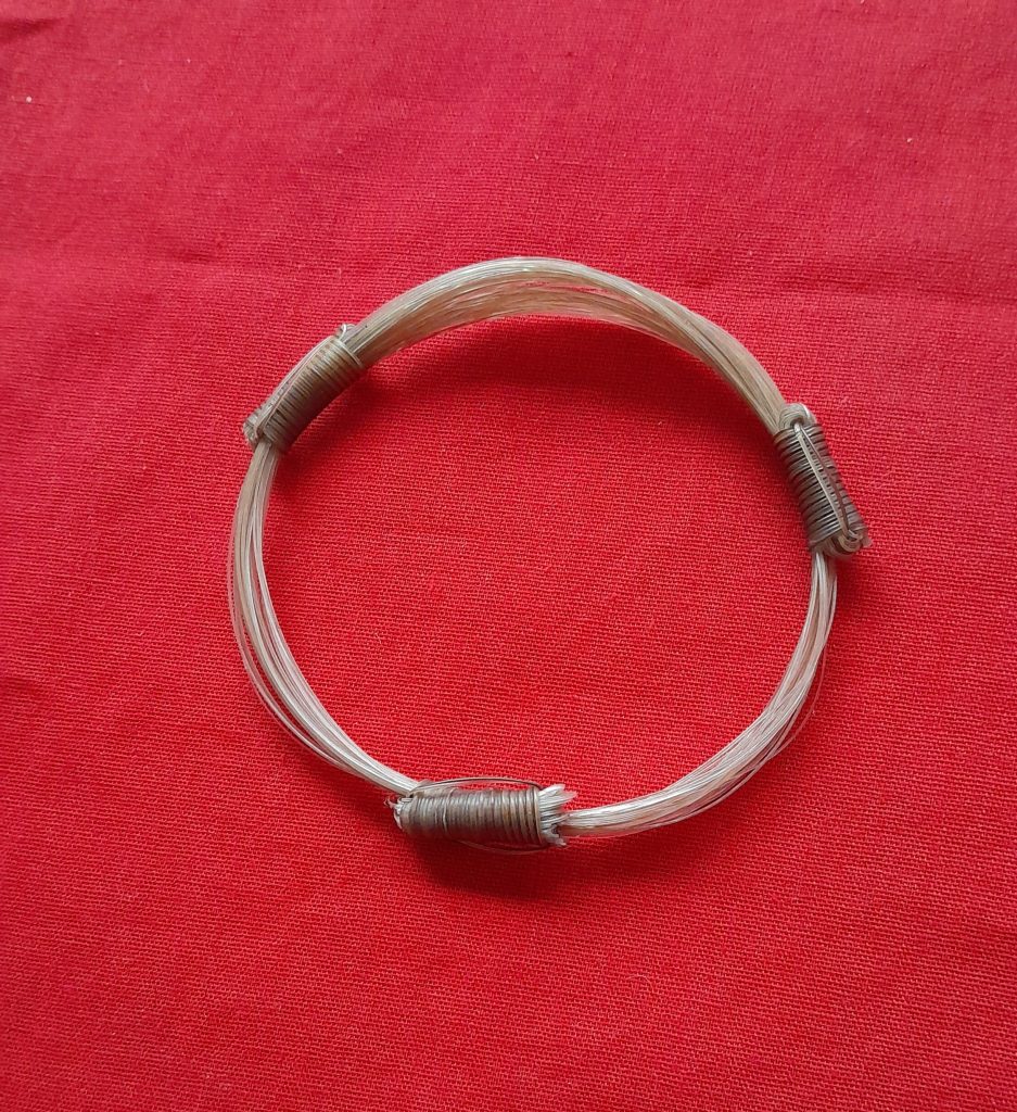 GIR15 Genuine white giraffe hair bracelet with light brown knots.